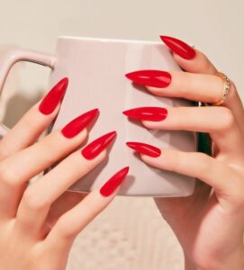 hand with red nails holding a mug